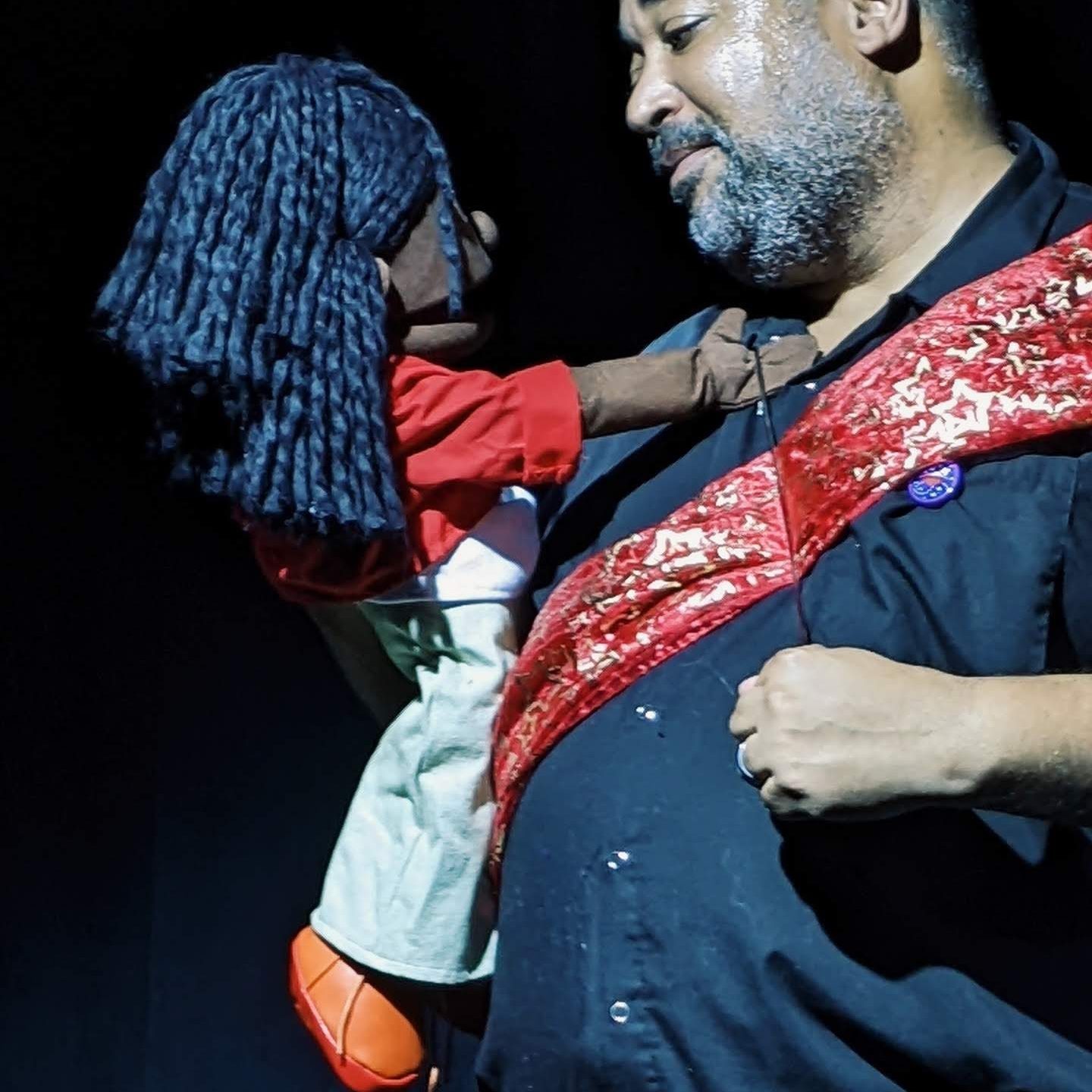 Photo from Ottawa Fringe Festival production of (Re)Tired Magical Black Man. Asase (Black female puppet) and dJerald (nonbinary Djinn) face each other, sharing platonic love. photo: Anna M